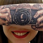 Ilusão de ótica de câmera fotográfica tatuada no braço