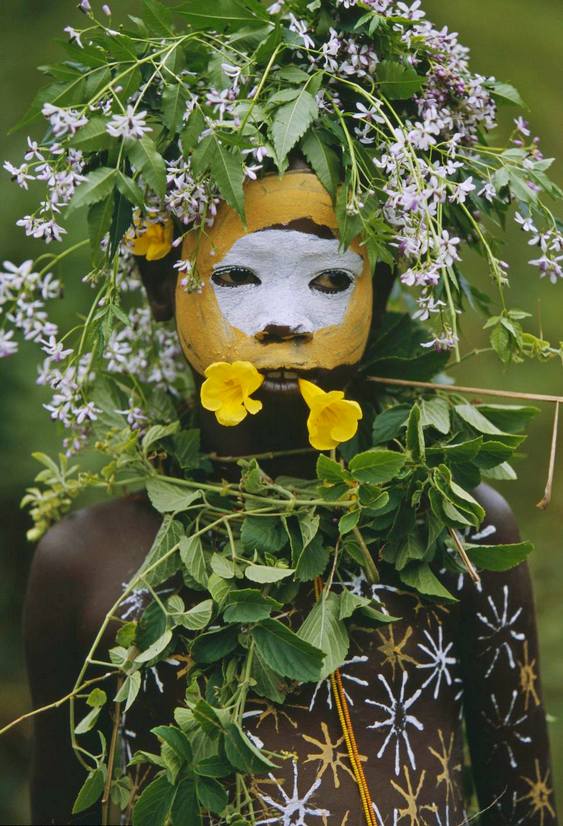 Criança nativa com flores e pintura corporal