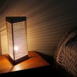 Uma luminária de cabeceira feita com madeira e elásticos
