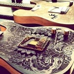 Guitarras com desenhos de tatuagem gravados na madeira