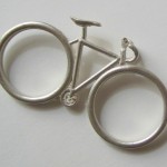 Réplica de bicicleta em miniatura inspira anel para dois dedos 
