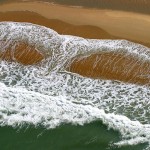Baleia mergulha na praia em imagem criada por espuma de onda