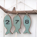 Números de endereço para casa de praia com peixes de madeira
