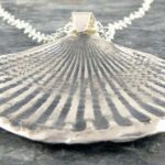 Pingente de prata com a forma de concha marinha fossilizada