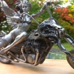 Escultura de mulher alada numa moto Harley-Davidson custom