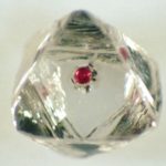 Diamante bruto com uma granada vermelha no seu interior