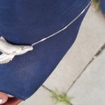 Baleia Jubarte 3D de prata sobre um sapato azul da cor do mar