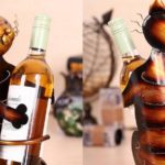Gato em chapa de metal como suporte para garrafas de vinho