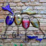 Painel com garrafas e taças de vinho na decoração de bar