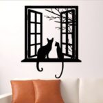 Gatos pretos sentados na janela em painel de metal