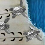 Painel 3D de metal com filhotes de tartarugas marinhas na praia