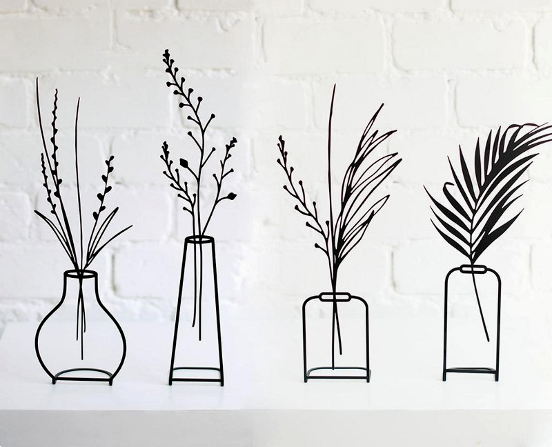 Vasos com plantas em esculturas minimalistas de ferro forjado