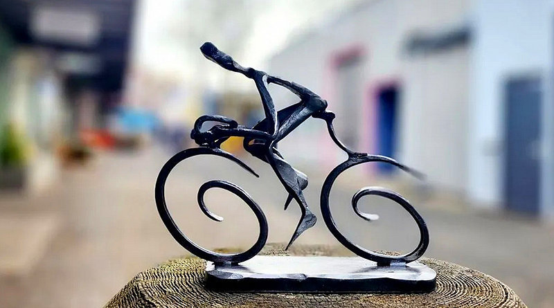 Arte em metal de ciclista pedalando bike