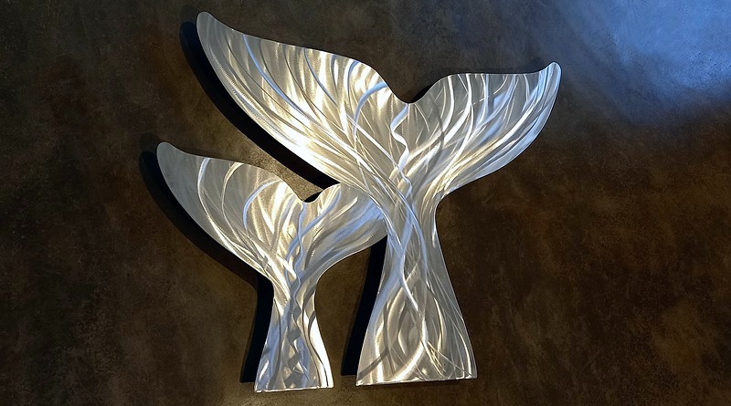 Escultura com rabos de baleias prateados